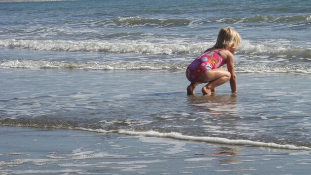 En strandscen med en person i badkläder.