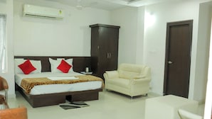 A bedroom with a bed, a wardrobe, a sofa, and a chair. - Hotel River View (Khagaria)
