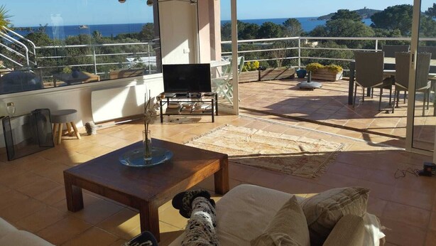 Un vaste espace de vie agrémenté d’une grande fenêtre donnant sur un paysage magnifique, d’une table basse en bois et d’un coin salon confortable.
