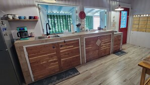 Una cocina con un armario de madera, una cafetera y un lavabo.