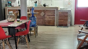 Un comedor espacioso con techo alto, vigas a la vista y un dispensador grande de agua.