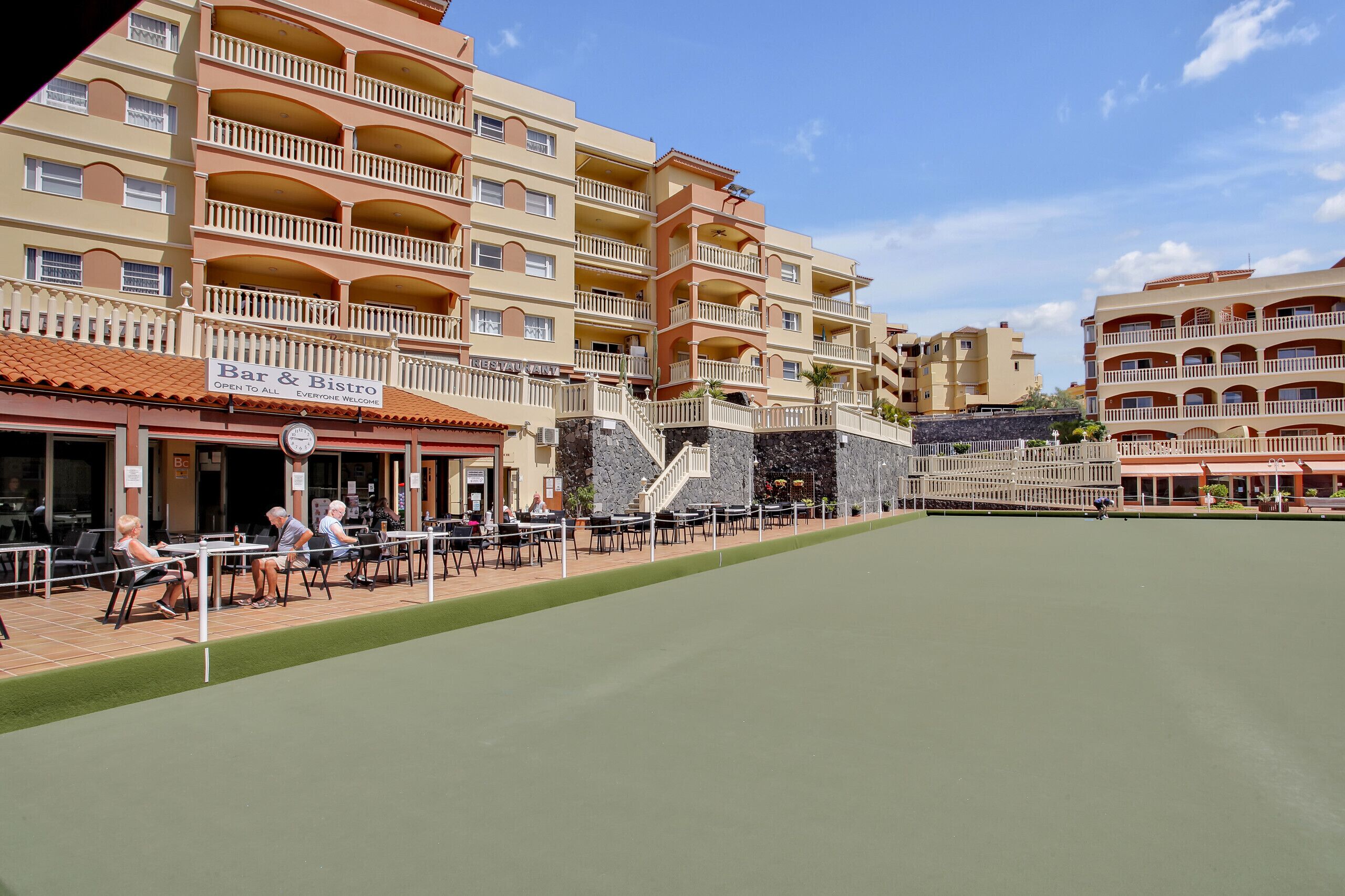 Ein mehrstöckiges Hotel mit Außenbereichen zum Sitzen und einer Bar und einem Bistro.