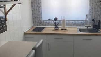 Een magnetron, een oven, een kookplaat, keukenrol