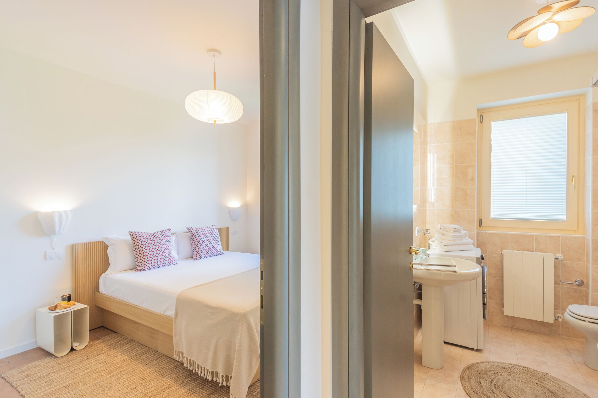 A modern bedroom with a bed, bedside table, and a nightstand.