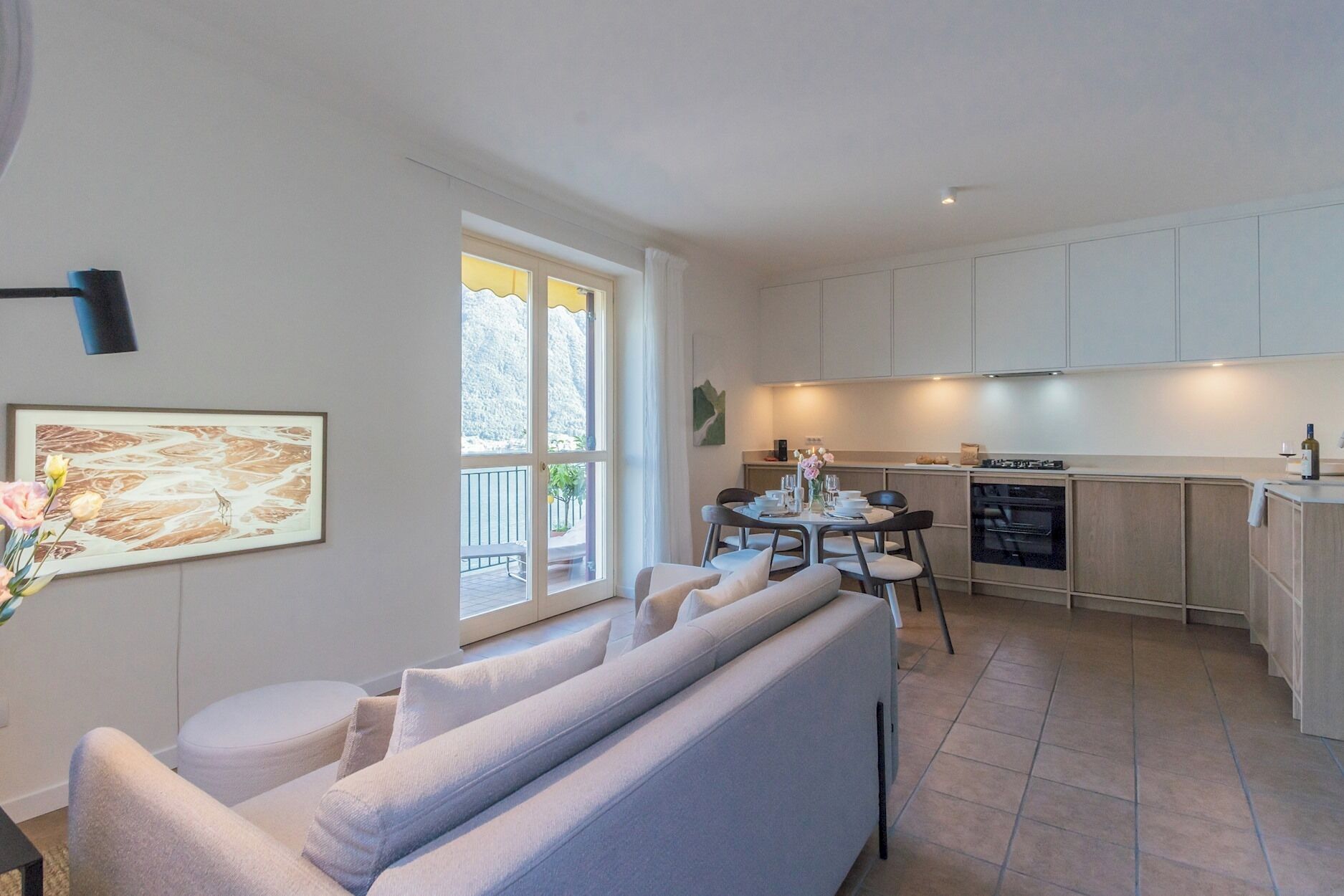 A modern living room with a sofa and a dining area with a table set for four.