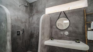 A bathroom with a shower, a sink, and a mirror.