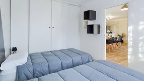 A bedroom with a bed, a wardrobe, and a dining area visible through an open door. - Bourg d'Olonne s/Mer, charming house for 6 people (Les Sables-d´Olonne)