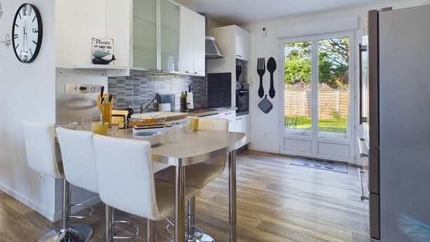 A modern kitchen with a bar area, stainless steel appliances, and a dining set. - Bourg d'Olonne s/Mer, charming house for 6 people (Les Sables-d´Olonne)