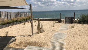 A sandy beach area with a wooden deck and a wooden fence. - Pool, view and beach access, 6 adults/2 children (La Guérinière)