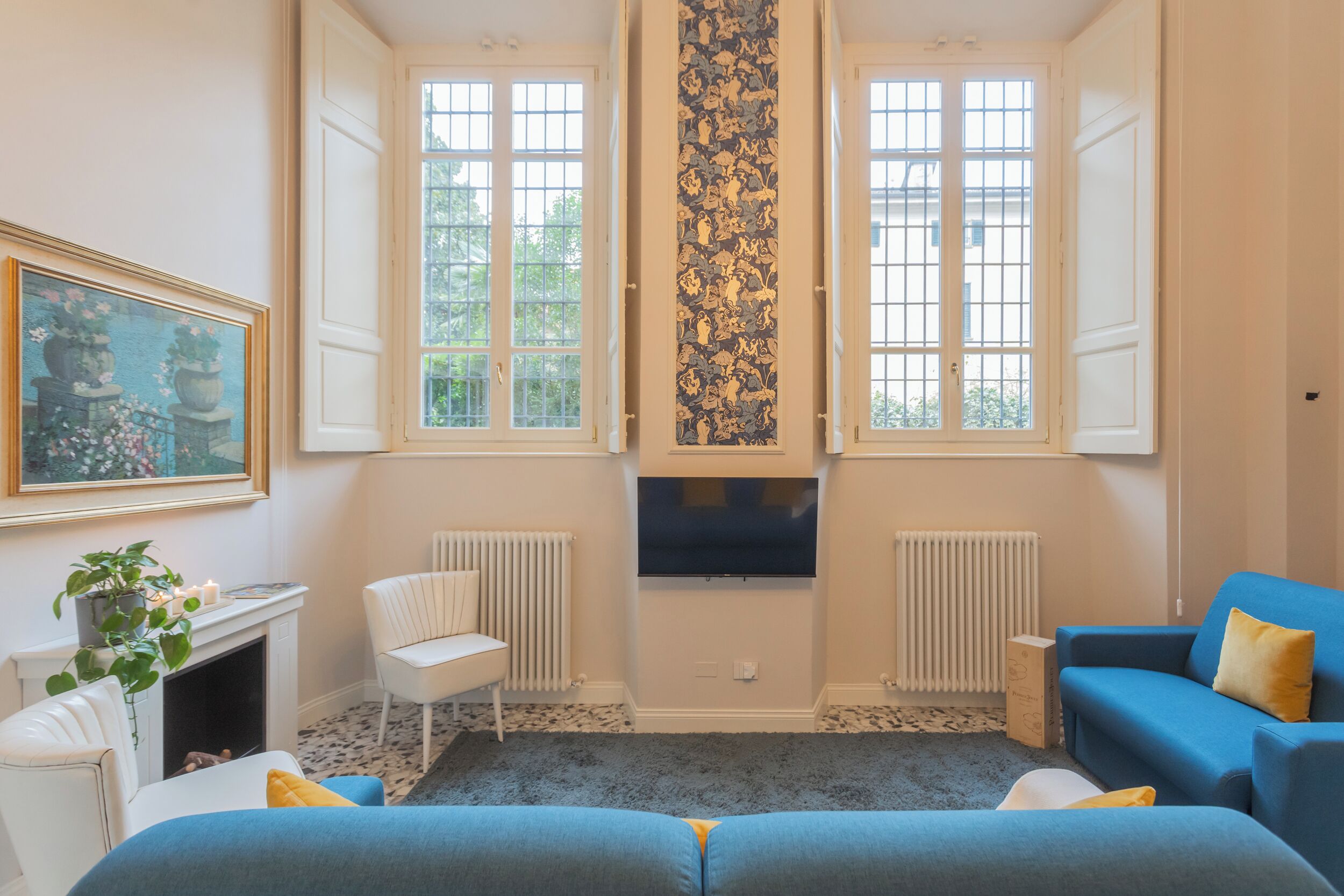 A room with a fireplace, a TV mounted on the wall, and a blue sofa.