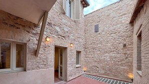A stone building with a narrow courtyard, large windows, and exterior lighting. - Stunning home in Spello with WiFi (Spello)