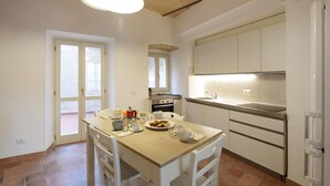 A compact kitchen with a dining area, featuring a stove, sink, and a window with a view. - Stunning home in Spello with WiFi (Spello)