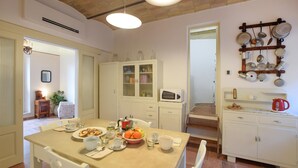 A cozy kitchen with a dining table set for two, a microwave, and a hanging pot rack. - Stunning home in Spello with WiFi (Spello)