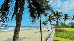 A beach with palm trees, a lifeguard tower, and a clear sky.