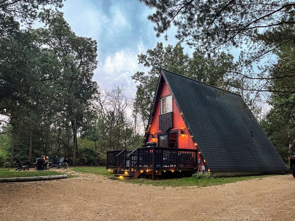 Eine Hütte mit geneigtem Dach, einer Terrasse und einer kleinen Veranda.