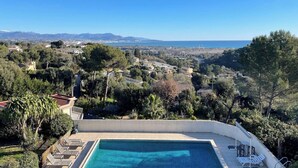 A swimming pool with a view of a coastal town and mountains in the distance. - TOP VILLA PALOMA ANTIBES Vue Mer, Montagne, FIBRE, CLIME, POOL (Antibes)