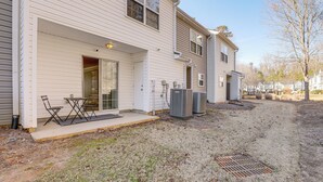 A two-story house with a covered patio, outdoor air conditioning units, and a visible garage door. - 8 Mi to Downtown: Atlanta Townhome! (Atlanta)