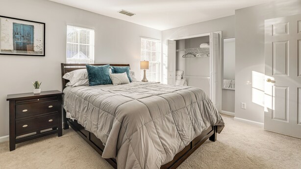 A bedroom with a bed, nightstand, dresser, and a walk-in closet. - 8 Mi to Downtown: Atlanta Townhome! (Atlanta)