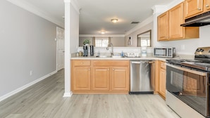 A modern kitchen with wooden cabinets, stainless steel appliances, and a central island. - 8 Mi to Downtown: Atlanta Townhome! (Atlanta)