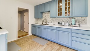A kitchen with blue cabinets, a white countertop, and a tiled backsplash. - Cozy Home w/ Grill & Games in Albuquerque! (Albuquerque)