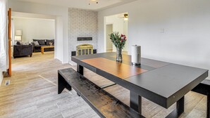 A modern dining area with a wooden table, benches, and a ceiling fan. - Cozy Home w/ Grill & Games in Albuquerque! (Albuquerque)