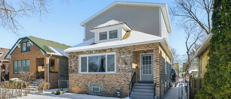A two-story house with a brick exterior, a stone facade, and a front porch.