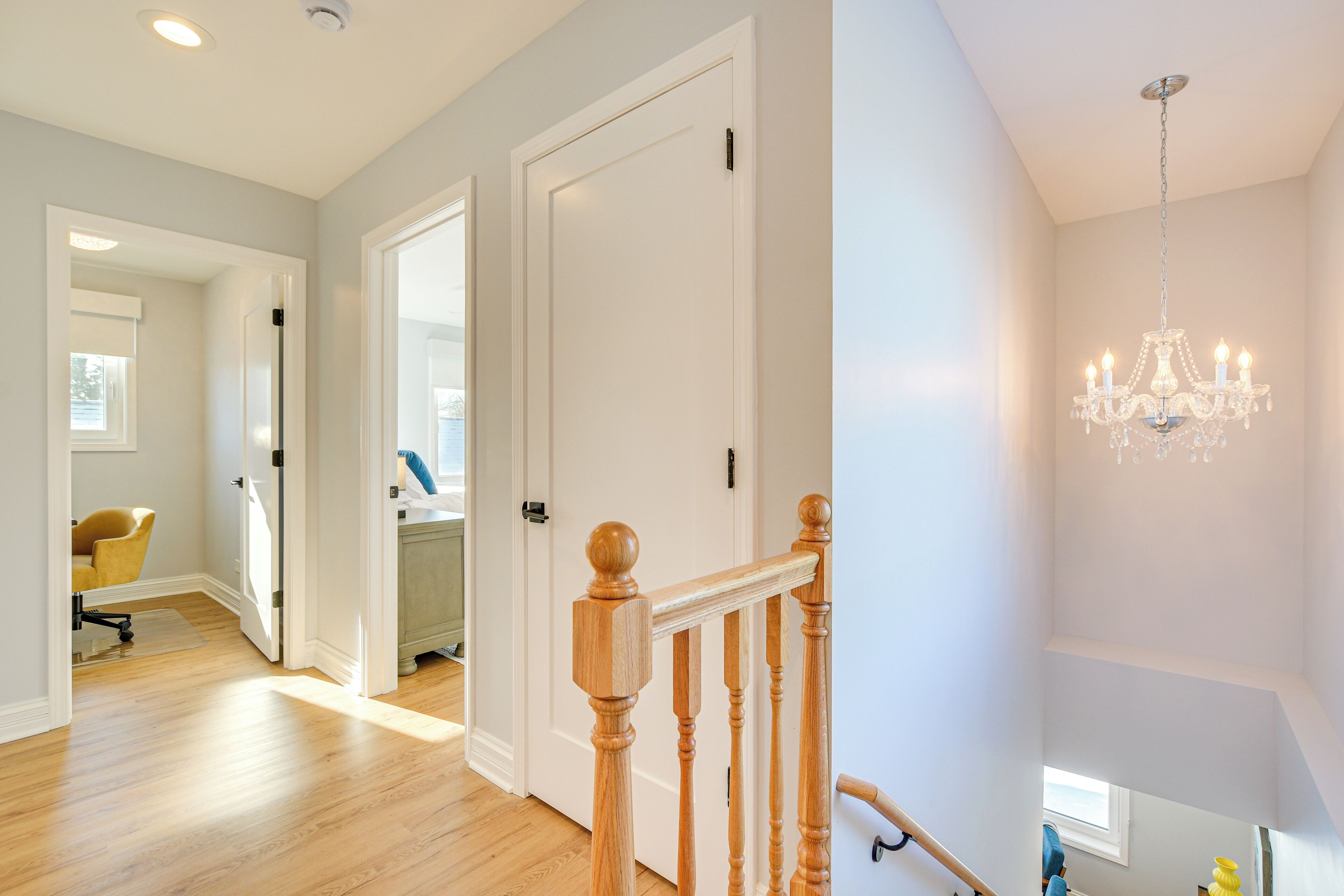 A staircase with wooden balusters and a chandelier.