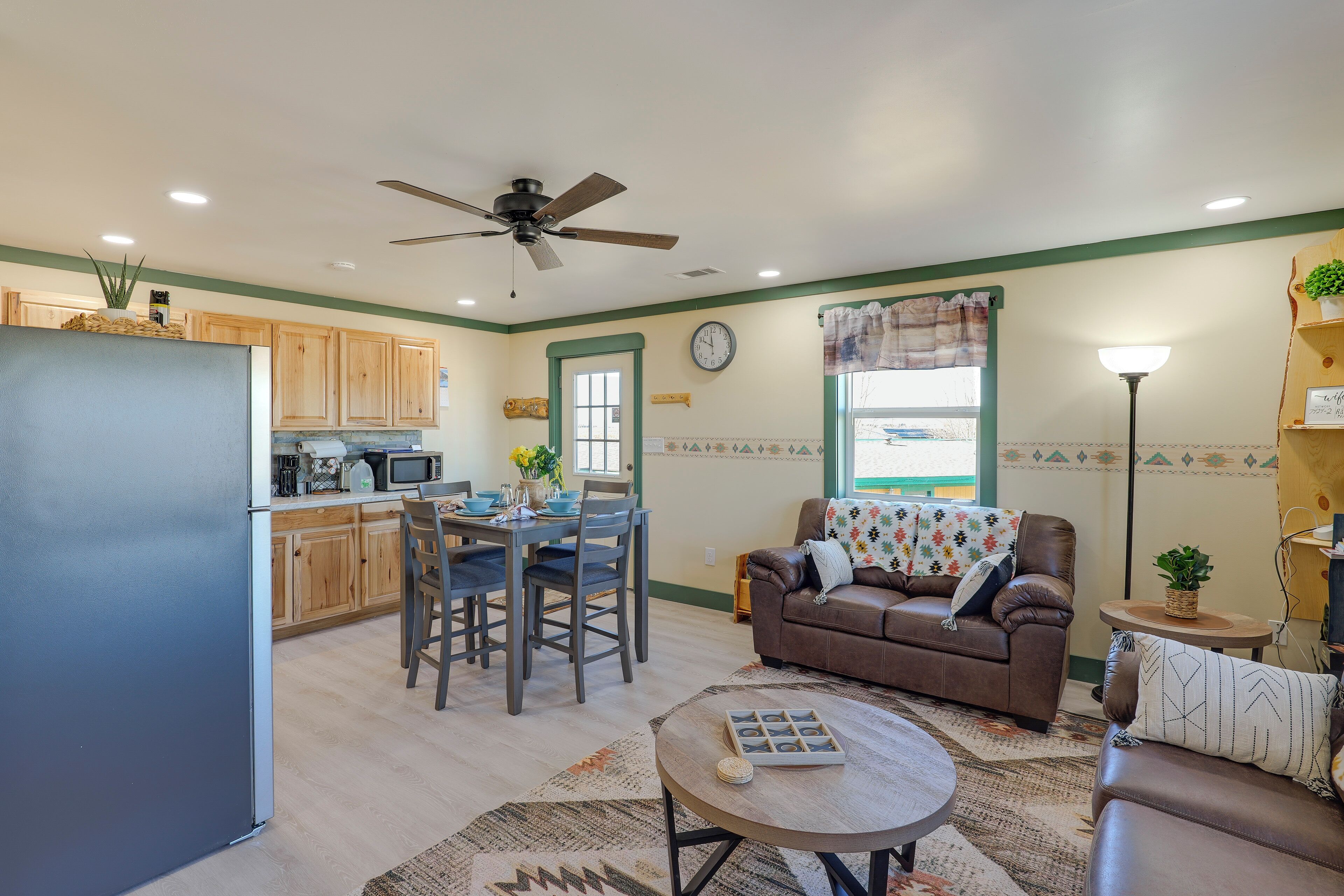 A compact living space with a kitchenette, dining area, and a seating area with a sofa and coffee table.
