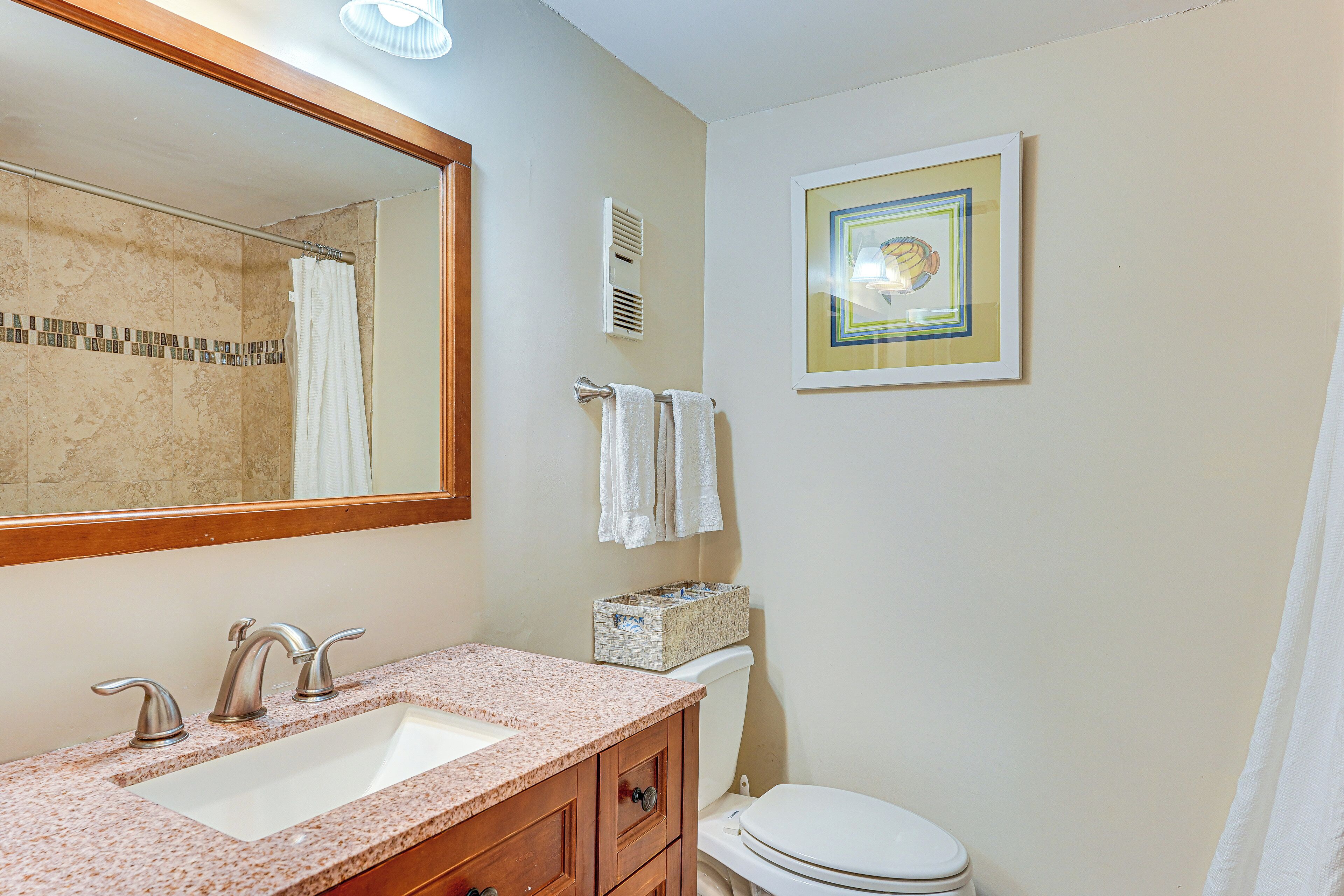 A bathroom with a sink, mirror, towel rack, and toilet.