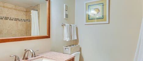 A bathroom with a sink, mirror, towel rack, and toilet.