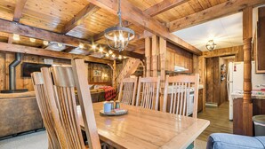 A wooden interior with a dining table, chairs, and a kitchen area. - 2 Mi to Schuss Mountain: Cozy Cabin w/ Deck (Bellaire)