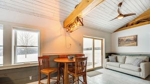 A spacious living area with a wooden dining table and chairs, a sofa, and a ceiling fan. - Ride From Your Door: Cabin w/ Vast Trail Access! (Hardwick)