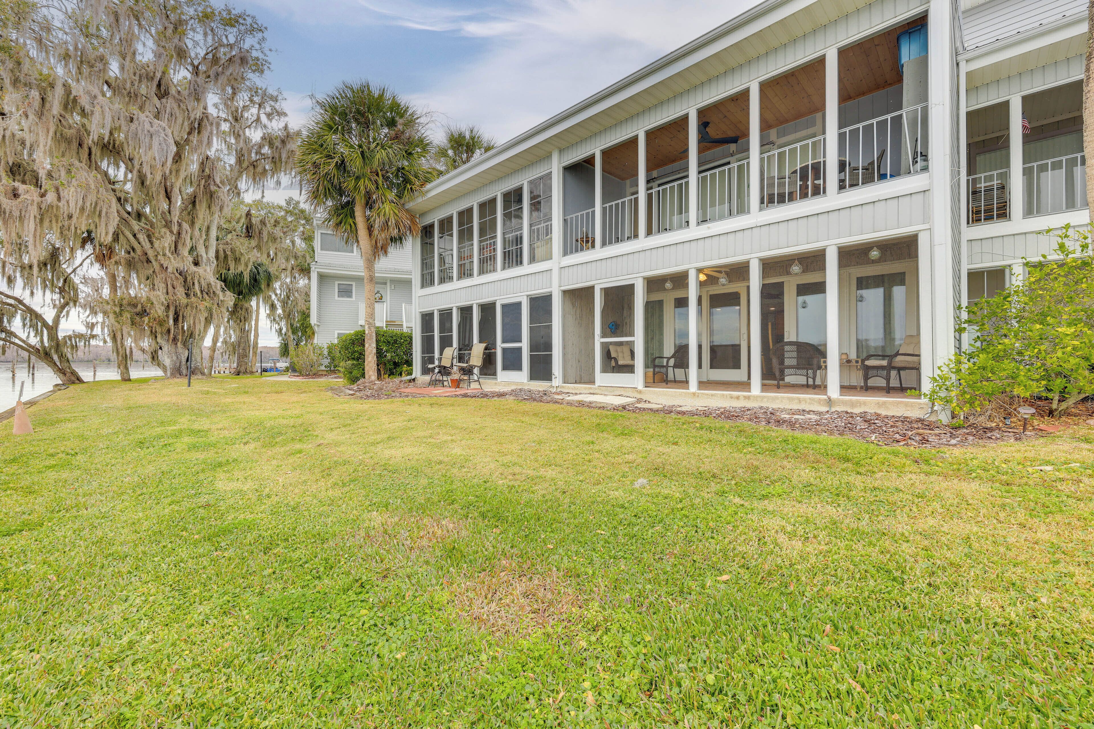 A two-story building with a covered outdoor area and a grassy lawn.