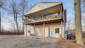 A two-story building with a balcony, a covered porch, and a gravel driveway. - Rustic Apartment w/ Sunset Views in Elkhart! (Elkhart)
