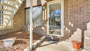 A brick building with a covered porch, a potted plant, and a concrete step leading to the entrance. - 15 Mi to Greensboro: Archdale Condo w/ Fireplace (High Point)