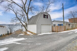 Una casa de un piso con garaje, cerca con madera y una entrada de vehículos que lleva a la puerta del garaje.