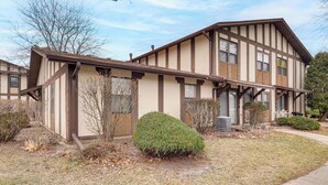 A two-story building with a gabled roof and a covered porch. - 3 Mi to Credit Union 1 Amphitheatre: Suburban Stay (Country Club Hills)