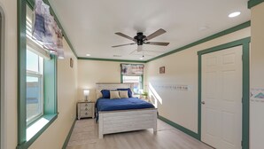 A bedroom with a bed, a nightstand, a ceiling fan, a window with blinds, and a door. - 9 Mi to Lake Carlsbad: Pet-friendly Apt (Carlsbad)
