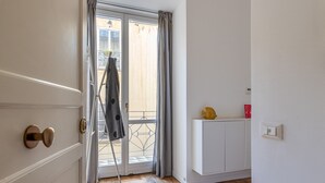 A room with a sliding glass door leading to a balcony, a white cabinet, and a yellow object on top. - La Casa al Foro con Vista Mare by Wonderful Italy (Palermo)