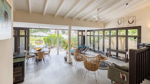 A spacious patio area with a dining table, chairs, and a lounge area with a sofa and chairs. - Indigo Garden at Blue Bay Golf Beach Resort (Sint Michiel)