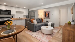 A modern kitchen with white cabinets, a microwave, and a refrigerator.