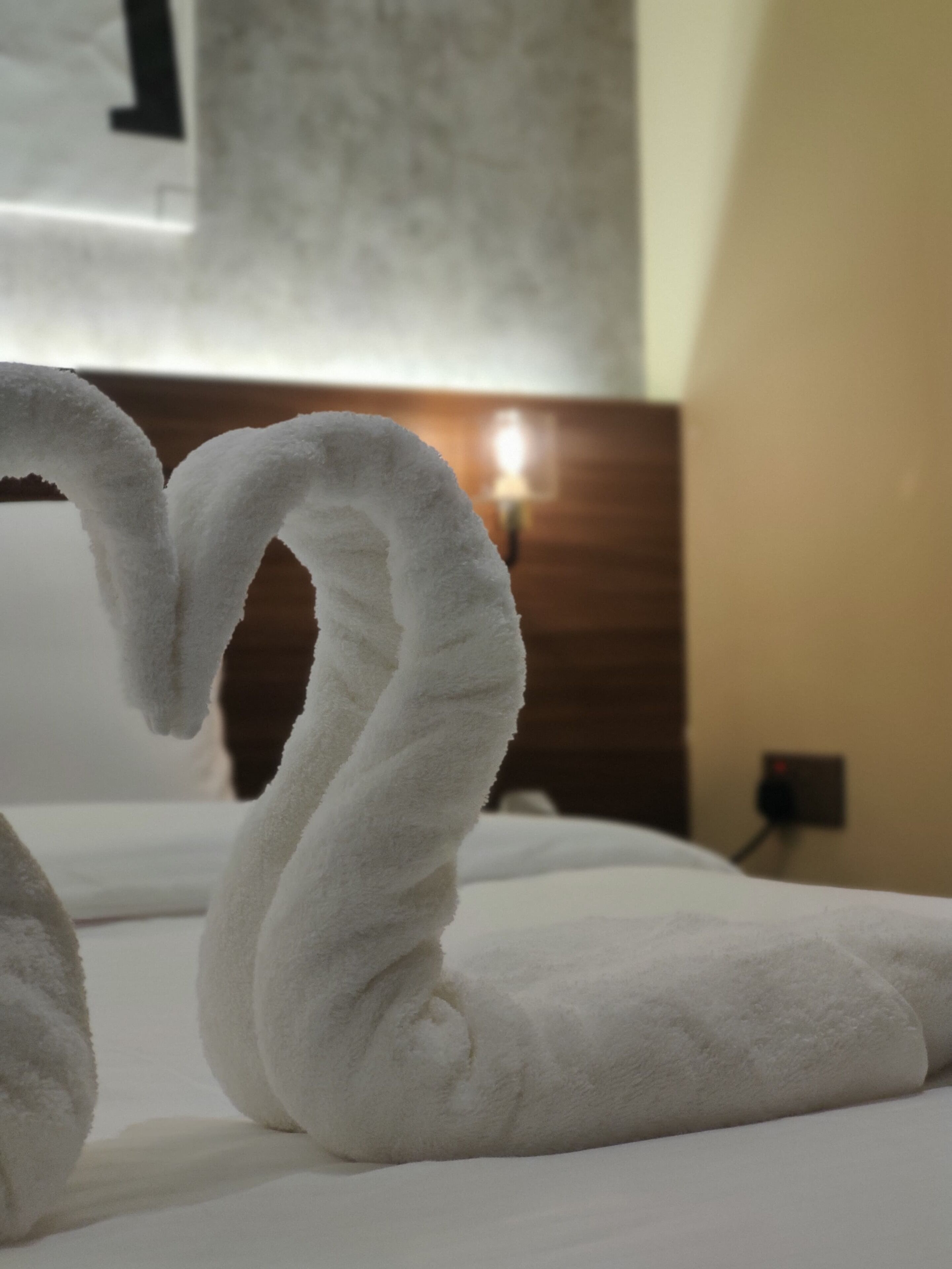 Een bed met een handdoekopstelling in de vorm van een hart.