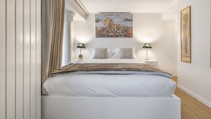A modern hotel room with a large bed, two bedside tables, a painting above the bed, and a window with curtains. - Ballerine, 3BR/2BA, 6 people (París)