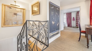 A hallway with artwork on the walls, a staircase with a metal railing, and a dining area with a table and chairs. - Ballerine, 3BR/2BA, 6 people (París)