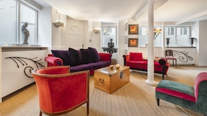 A spacious living room with a herringbone-patterned carpet, a wooden coffee table, and a red armchair. - Ballerine, 3BR/2BA, 6 people (París)
