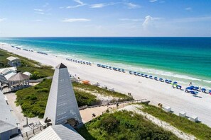 A beach with a long row of umbrellas and a large pyramid-shaped building in the foreground. - Sleeps 21! Private Pool, Game Room, LSV, Bikes, & Carriage House! (Seacrest)