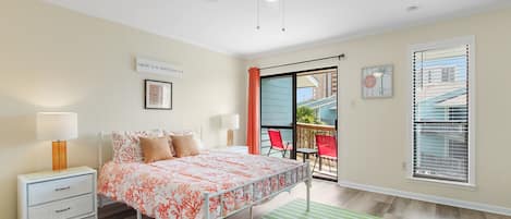 Un dormitorio con cama, mesita de noche y vista al balcón exterior.