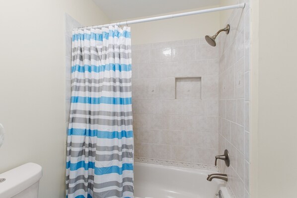 A bathroom with a shower, a toilet, and a bathtub. - The Sands 107 (Gulf Shores)