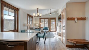 Una cocina amplia con una isla central, suelo de madera y grandes ventanales con vistas.