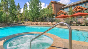 A pool with a hot tub, lounge chairs, and umbrellas. - Spacious Upstairs Townhome With Private Garage 2 Bedroom Condo (Breckenridge)